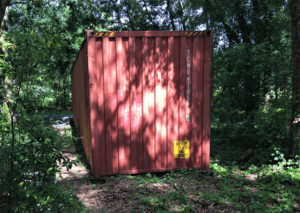 Red storage container in woods