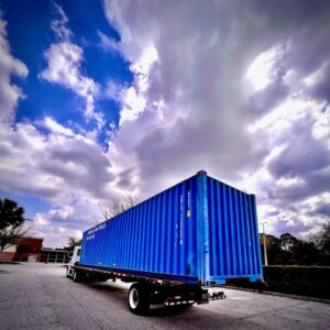 BLUE CONTAINER LOADED ON TRUCK